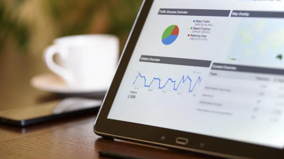 Tablet showing rental income charts next to a coffee cup